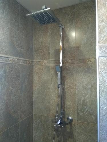 a shower with a shower head in a bathroom at Вила Цветелина, Комплекс Александриa in Dobrinishte