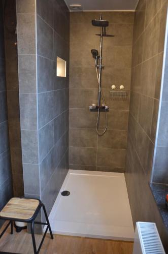 een badkamer met een douche, een bank en een kruk bij 4 rue du Balloir in La-Roche-en-Ardenne