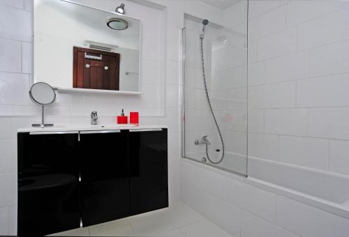 a white bathroom with a shower and a sink at Ocean View in Estoril - Checkinhome in Estoril