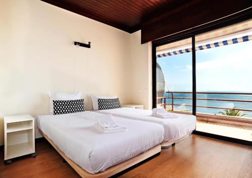 a bedroom with a large bed and a large window at Ocean View in Estoril - Checkinhome in Estoril