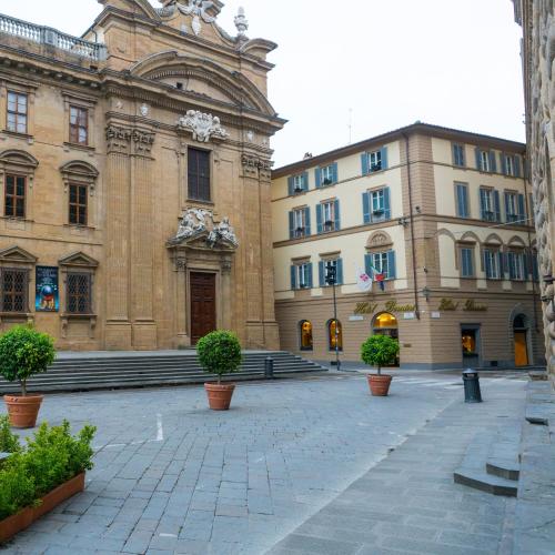 a large building with potted plants in front of it at Hotel Bernini Palace in Florence
