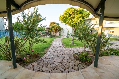 a garden with a stone walkway and trees at Villa Sophia in Mitikas
