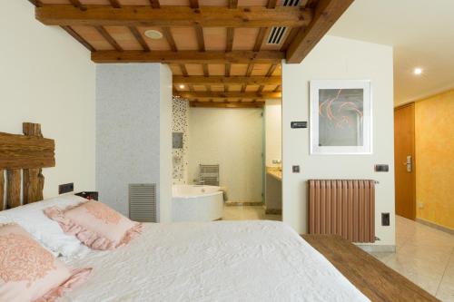 a bedroom with a bed and a tub in a bathroom at Hotel Històric in Girona