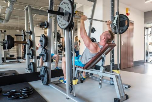 a man in the gym lifting a barbell at Grand Nosalowy Dwór in Zakopane