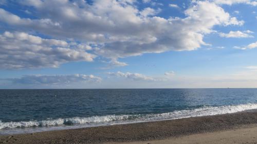 a beach with a cloudy sky and the ocean at Fattoria Armonia in Stilo
