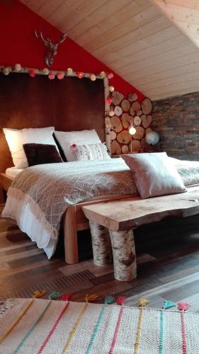a bedroom with a large bed and a bench at Villa Étienne in Le Mont-Dore
