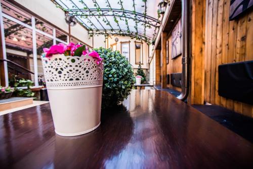 a large pot of flowers sitting on a wooden floor at Art Hotel in Krasnodar