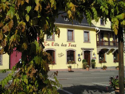 a yellow building with a sign that reads real life dog paw at Logis Hôtel Restaurant La Tête Des Faux in Le Bonhomme
