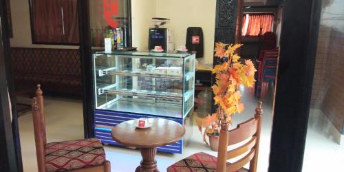 a glass cabinet with a table and two chairs at Hotel Silver Sand in Trivandrum