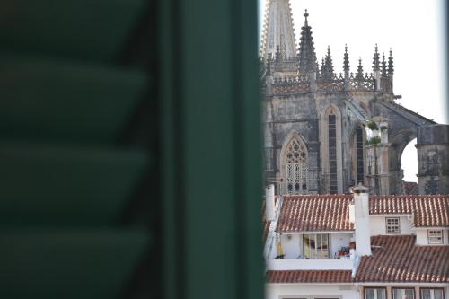 a view of a cathedral and roofs of buildings at Varandas do Mosteiro in Batalha