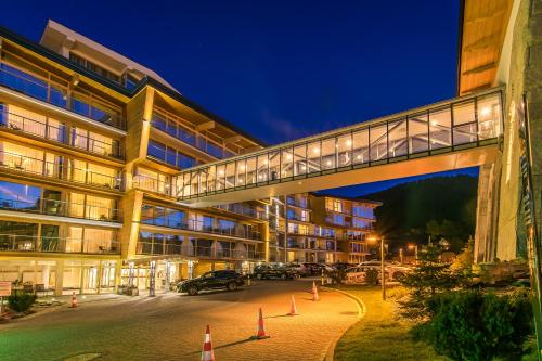 a building with a bridge over a street at night at Rezydencja Nosalowy Dwór in Zakopane