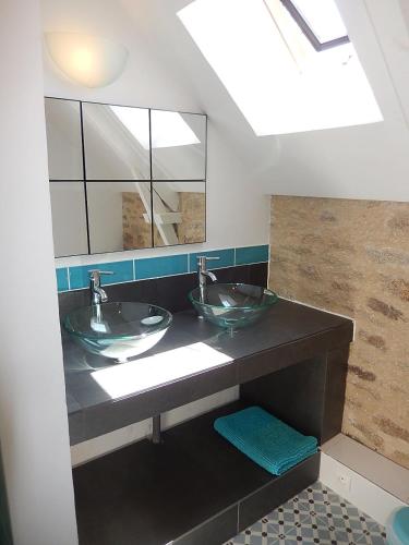 une salle de bain avec deux lavabos et un grand miroir dans l'établissement Chez Marianne, à Quiberon