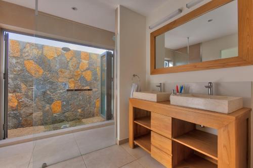 ein Bad mit einem Waschbecken und einer Dusche in der Unterkunft Villa Paradis in Grand Baie