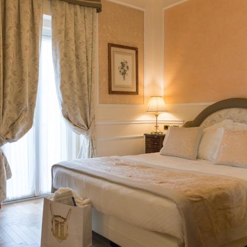a bedroom with a large bed and a window at Hotel Bernini Palace in Florence