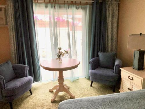 a room with two chairs and a table and a window at Sands Of Time Motor Inn & Harbor House in Woods Hole
