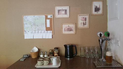a counter top with cups and glasses on it at Penzion Filoun in Plavy