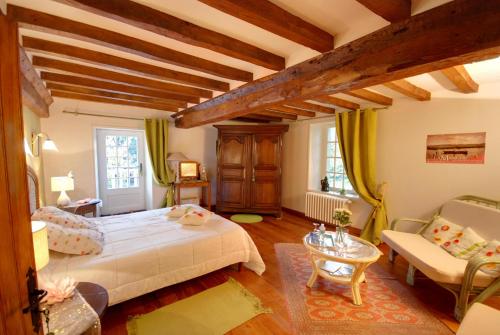 a bedroom with a white bed and a couch at La Faisanderie in Grandcamp-Maisy