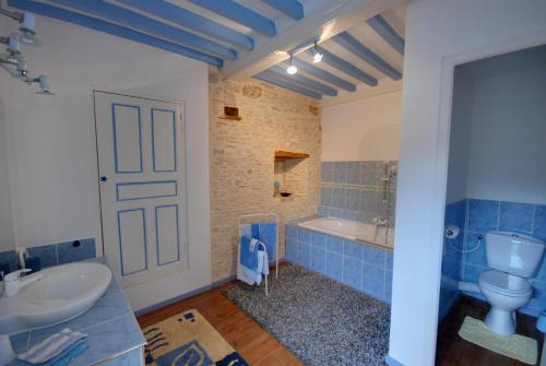 een badkamer met een wastafel, een toilet en een bad bij La Faisanderie in Grandcamp-Maisy