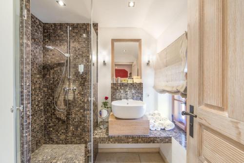 a bathroom with a shower and a white sink at Romantik Hotel Chalet am Kiental in Herrsching am Ammersee