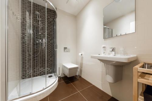 La salle de bains est pourvue d'une douche, d'un lavabo et de toilettes. dans l'établissement Sunny Riverside Apartments, à Prague