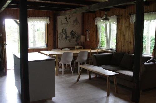 een woonkamer met een bank en een tafel bij Dom nad jeziorem in Borkowo