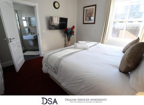 a bedroom with a large white bed and a window at Birmingham Central Station Apartment (Flat 2) in Birmingham