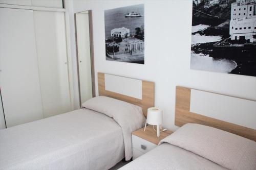 2 Betten in einem kleinen Zimmer mit Fenster in der Unterkunft Apartamentos Tao Laia in Puerto del Rosario