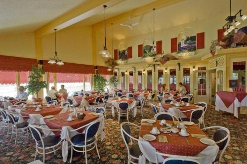 a restaurant with tables and chairs in a room at Hotellerie Jardins de Ville in Sherbrooke