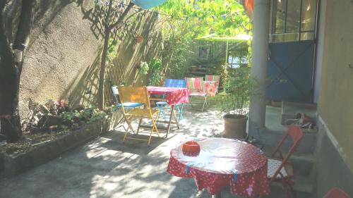 a patio with tables and chairs and a table with a cup on it at Chez Clairotte in Salinelles