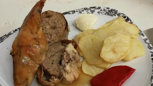un plato de comida con carne y patatas fritas en Hostal Casa Lacreu en Sahun