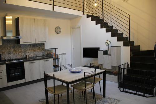 a kitchen with a table and chairs and a staircase at Il Piccolo Loft della Vela in Savona