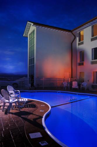 a swimming pool with two chairs next to a building at Savannah House Hotel in Branson