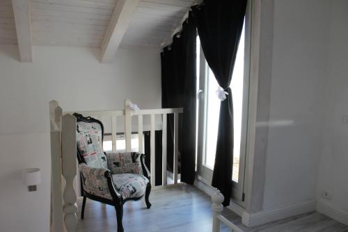 a chair sitting in a room with a window at Angels'Home A 'n D in Pizzo