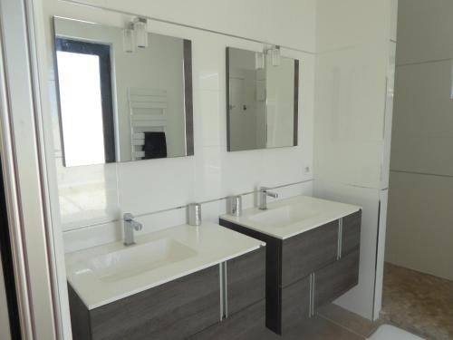 une salle de bain avec deux lavabos et un miroir dans l'établissement Villa Lucienne Bandol, Maison d'architecte, 5 étoiles, calanques, à Bandol