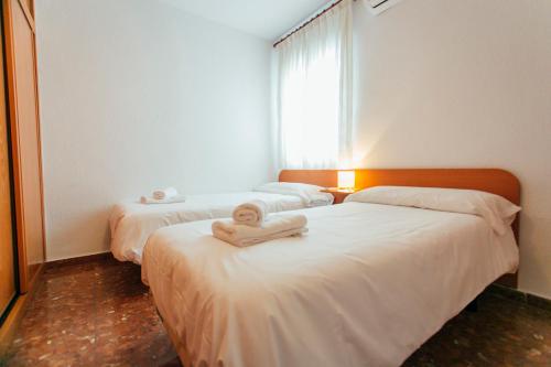 een kamer met twee bedden en een handdoek erop bij Comfortable- 2Bd 1Bth- Triana in Sevilla