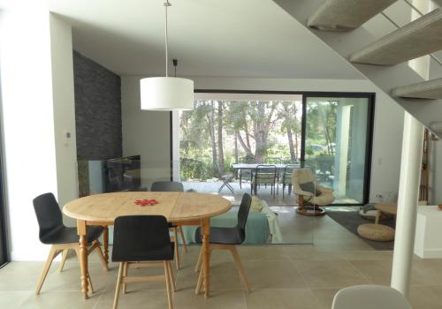 une salle à manger avec une table et des chaises dans l'établissement Villa Lucienne Bandol, Maison d'architecte, 5 étoiles, calanques, à Bandol
