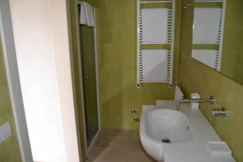 a bathroom with a tub and a sink and a mirror at Relais Masseria Villa Cenci in Cisternino