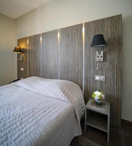 a bedroom with a bed and a table with a lamp at L'Escale in Bonifacio