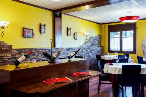 a restaurant with a bar with bottles of wine at Hostal La Plaça in Erill la Vall