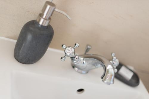 a bathroom sink with a soap dispenser and a faucet at Deighton Lodge in York