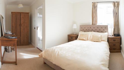 a bedroom with a bed and a desk and a window at Deighton Lodge in York