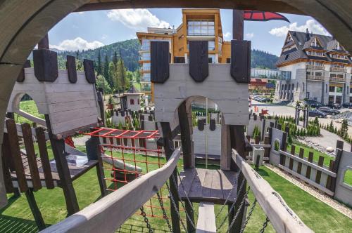 a view through an archway of a playground at Grand Nosalowy Dwór in Zakopane