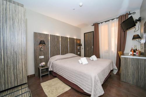 a bedroom with a large bed and a television at L'Escale in Bonifacio