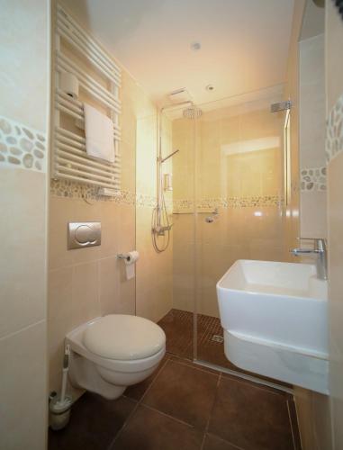 a bathroom with a toilet and a sink and a shower at L'Escale in Bonifacio