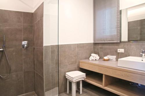 a bathroom with a sink and a shower at Hotel Flora in Lagundo