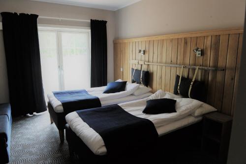 Säng eller sängar i ett rum på Tiraholms hotell