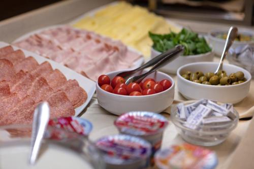 a table topped with different types of meats and vegetables at Smart Hotel Holiday in Mestre