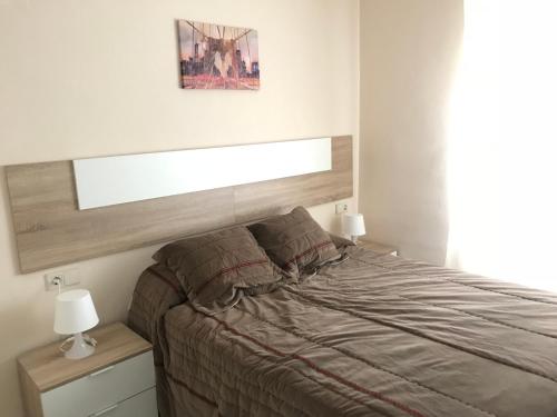 a bedroom with a bed with a wooden headboard at Apartamento Los Nidos (La Carihuela) in Torremolinos