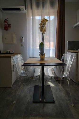 a dining room table with a vase of flowers on it at L'Escale in Bonifacio