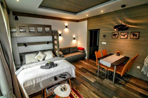 a bedroom with a bed and a table and a dining room at Prima Tatry in Starý Smokovec